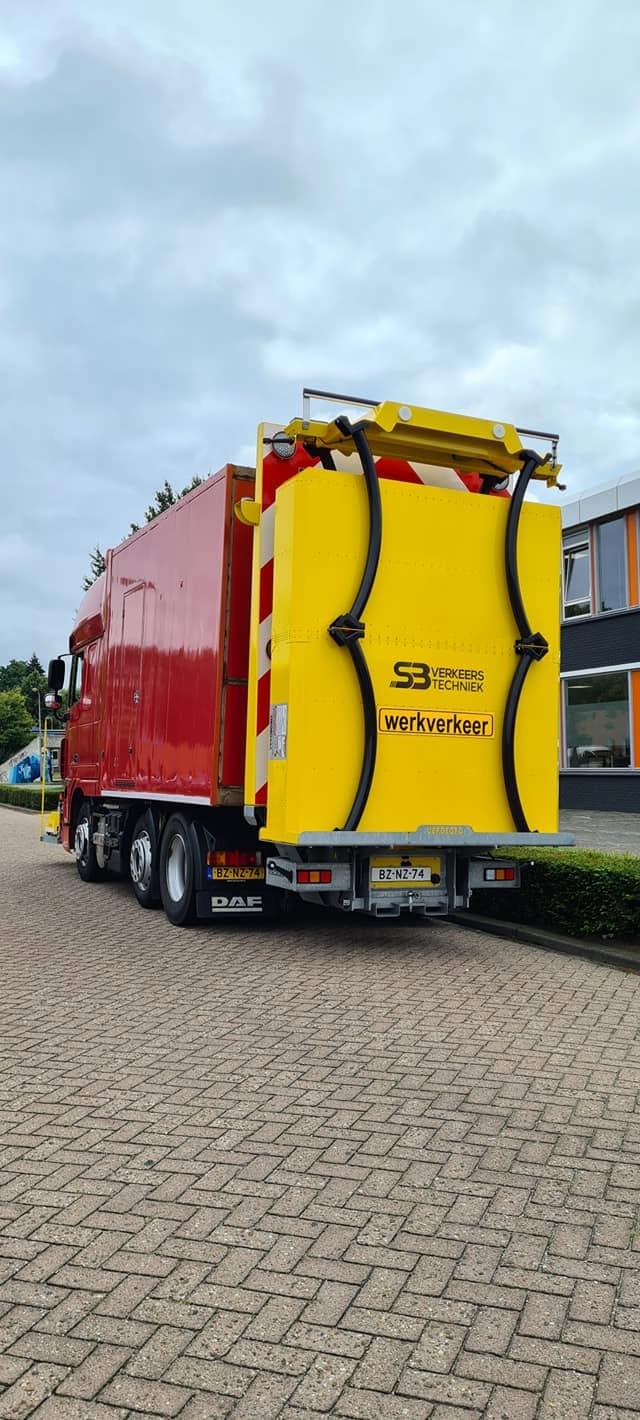 Rode DAF-truck van SB Verkeerstechniek met gele botsabsorber en werkverkeer-bord